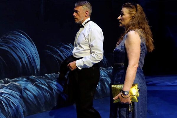 Ein Mann und eine Frau vor einem Bühnenbild zu "Lohengrin" von Neo Rauch